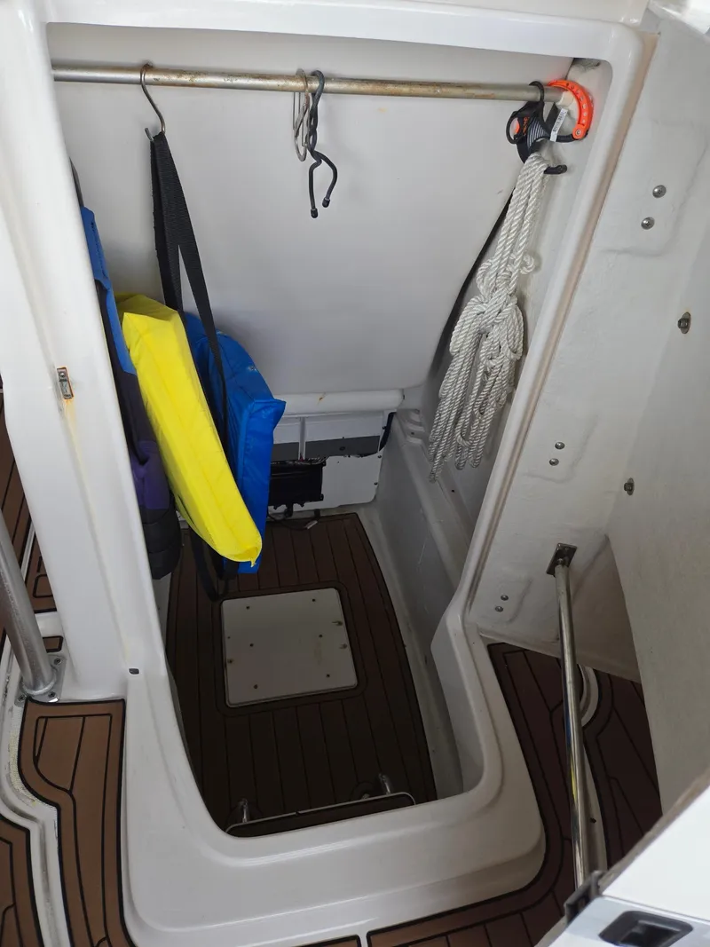 Slide: The Image of Storage compartment in 2014 Robalo R222 Center Console boat with life jackets and ropes. - 12