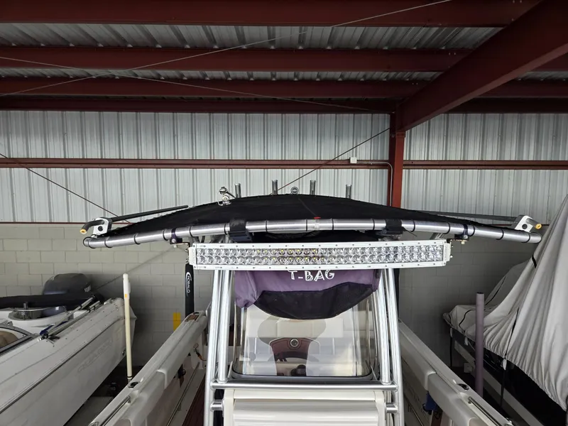 Slide: The Image of 2014 Robalo R222 Center Console boat under metal shelter. - 13