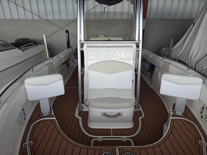 Slide: The Image of 2014 Robalo R222 Center Console boat interior with white seating and wood-style flooring. - 14