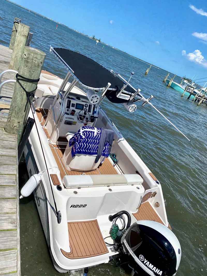 Slide: The Image of 2014 Robalo R222 Center Console boat docked by the water. - 3