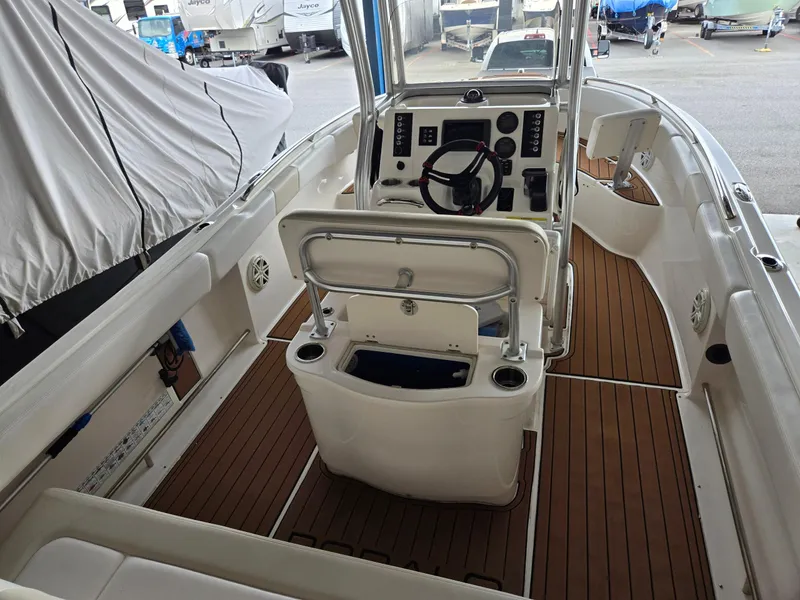 Slide: The Image of 2014 Robalo R222 Center Console boat interior with wood flooring and steering console. - 7