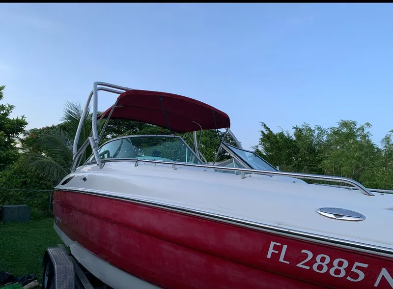 Slide: The Image of 2006 Monterey 268SS Super Sport boat with red hull and canopy, parked on trailer. - 11