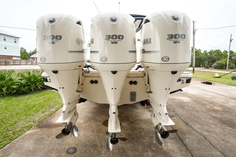 Slide: The Image of 2018 Chris-Craft Catalina 34 with triple Yamaha 300 engines, parked on concrete driveway. - 3