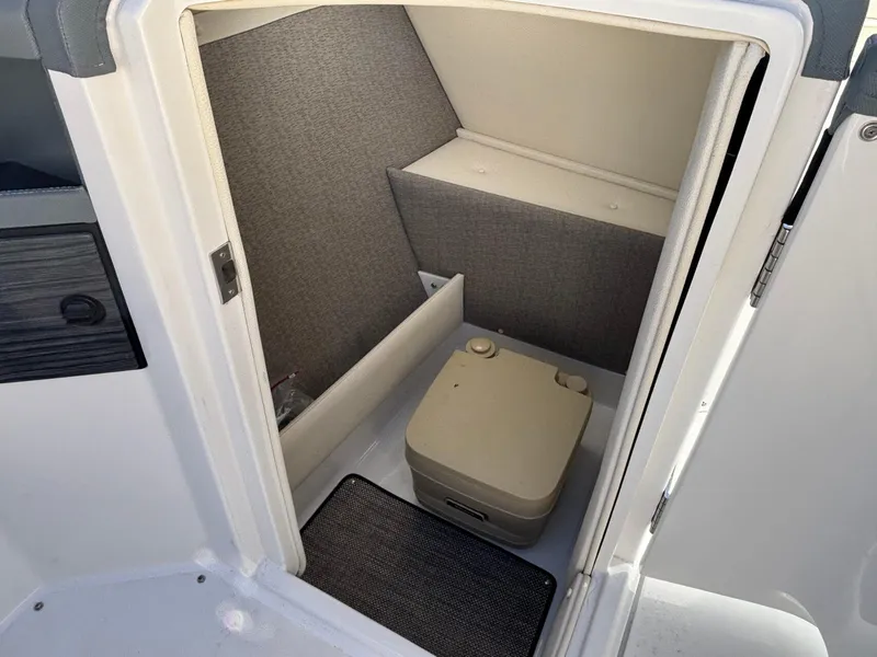 Slide: The Image of 2017 Cobalt R5 boat interior with compact portable toilet in small compartment. - 14