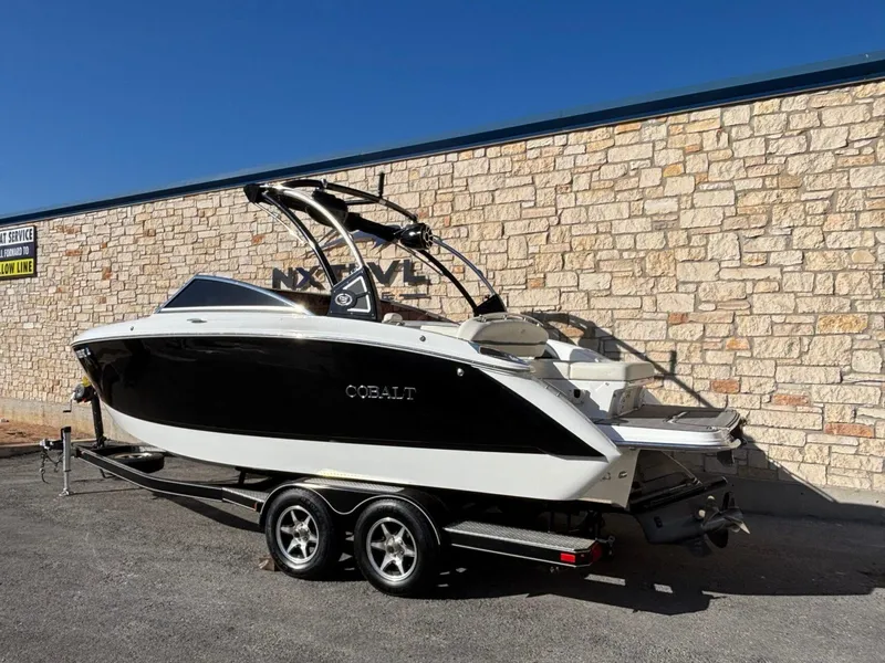 Slide: The Image of 2017 Cobalt R5 boat on trailer, parked beside a stone wall under clear blue sky. - 3