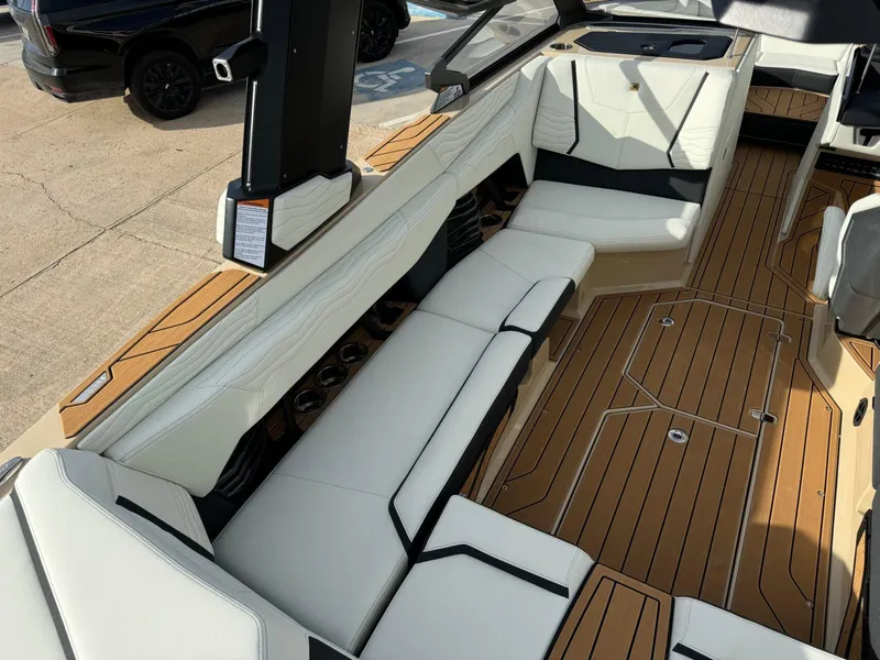 Slide: The Image of 2025 Nautique G23 boat interior with white seating and teak flooring. - 14
