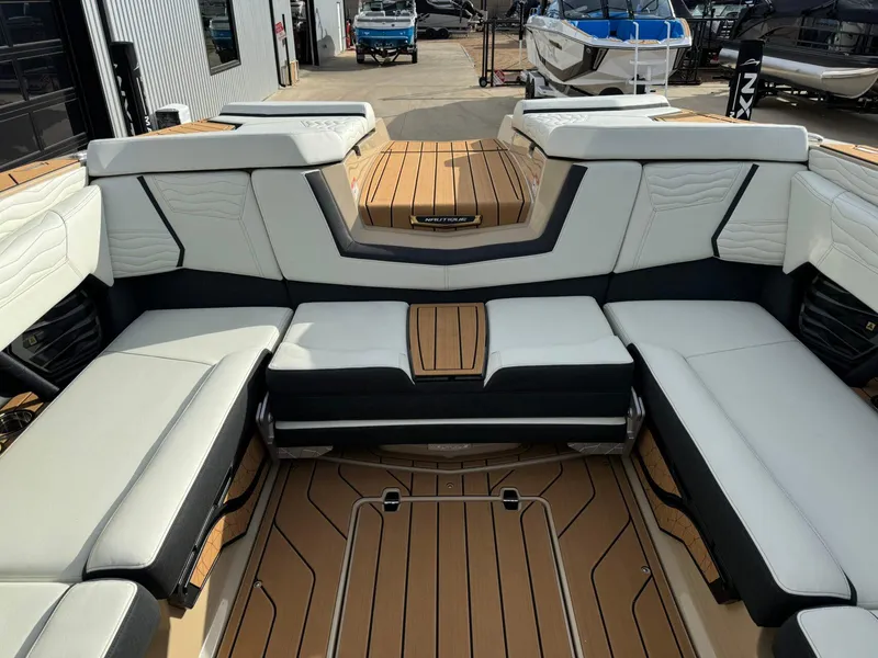 Slide: The Image of 2025 Nautique G23 boat interior with luxurious seating and teak flooring. - 17