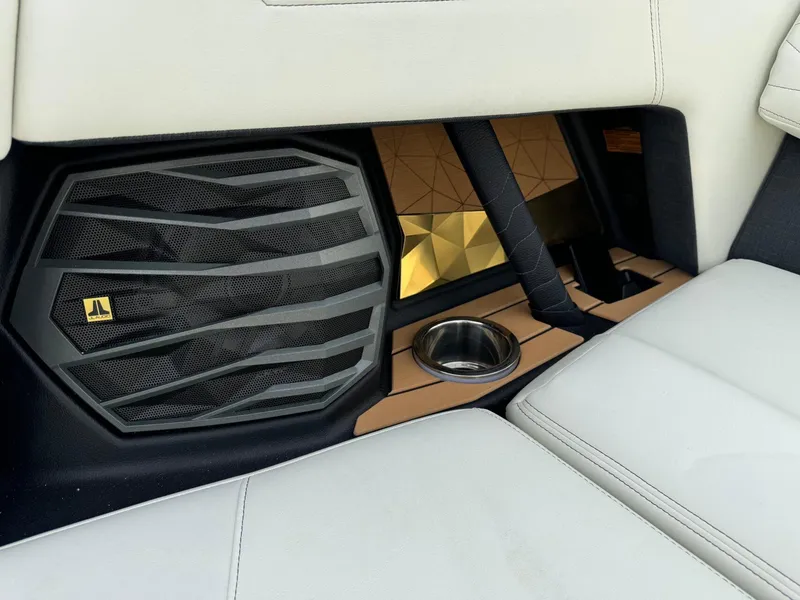 Slide: The Image of 2025 Nautique G23 interior with speaker, cup holder, and luxurious seating. - 20