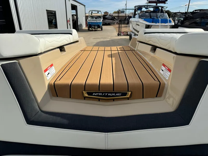 Slide: The Image of 2025 Nautique G23 boat with teak deck, docked at marina. - 24