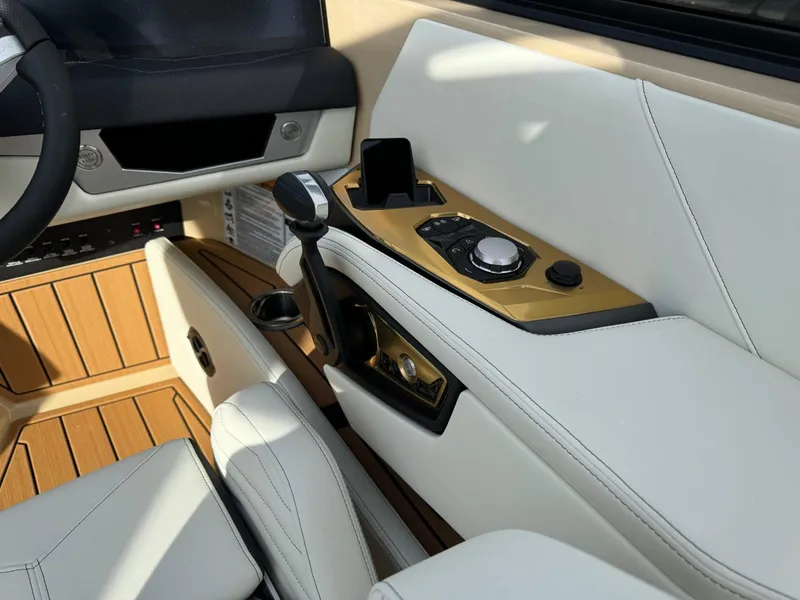 Slide: The Image of 2025 Nautique G23 interior with modern controls and luxurious white seating. - 28