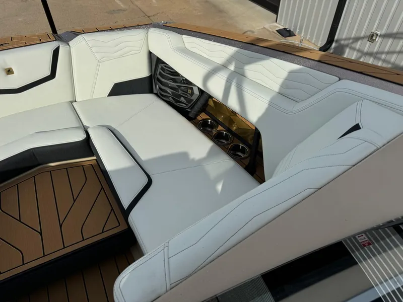 Slide: The Image of 2025 Nautique G23 boat interior with white seating and wood accents. - 35