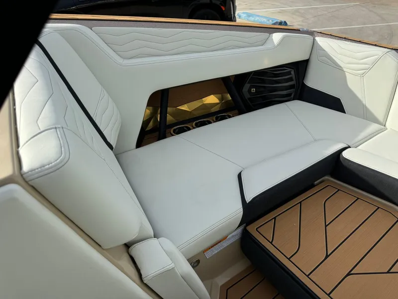 Slide: The Image of 2025 Nautique G23 boat interior with white leather seating and teak flooring. - 37