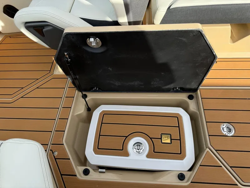Slide: The Image of 2025 Nautique G23 boat storage compartment with teak flooring and white seating. - 44
