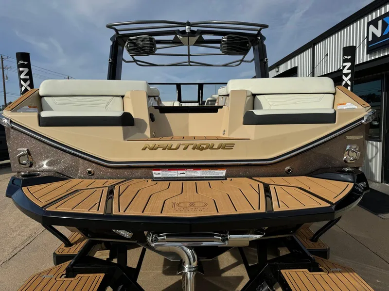 Slide: The Image of 2025 Nautique G23 boat with tan upholstery and teak swim platform. - 5