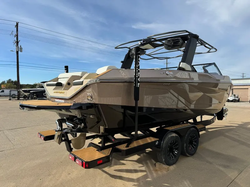 Slide: The Image of 2025 Nautique G23 boat on trailer, sleek design, parked outdoors under clear sky. - 6
