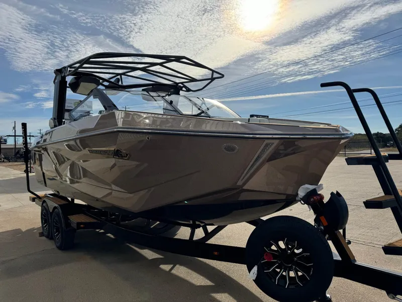 Slide: The Image of 2025 Nautique G23 boat on trailer under sunny sky. - 7