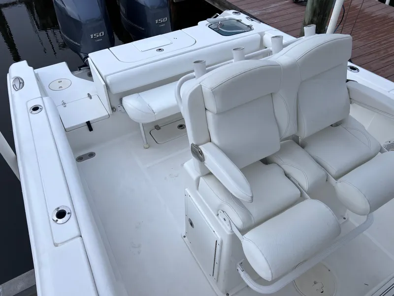 Slide: The Image of 2017 Sea Hunt Gamefish 25 boat interior with white seating and dual engines. - 14