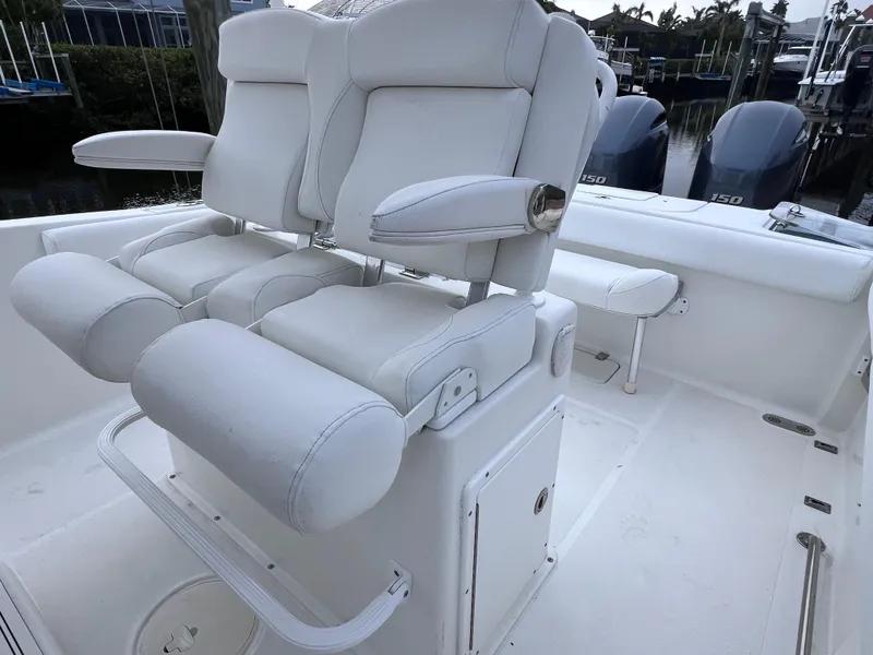 Slide: The Image of 2017 Sea Hunt Gamefish 25 boat interior with white seating and dual engines. - 15