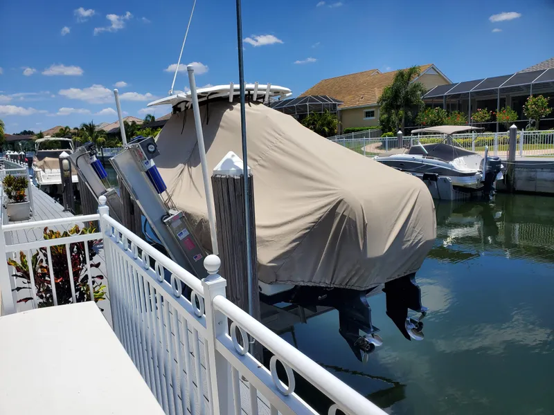 Slide: The Image of 2017 Sea Hunt Gamefish 25 boat covered and docked in a sunny canal. - 8