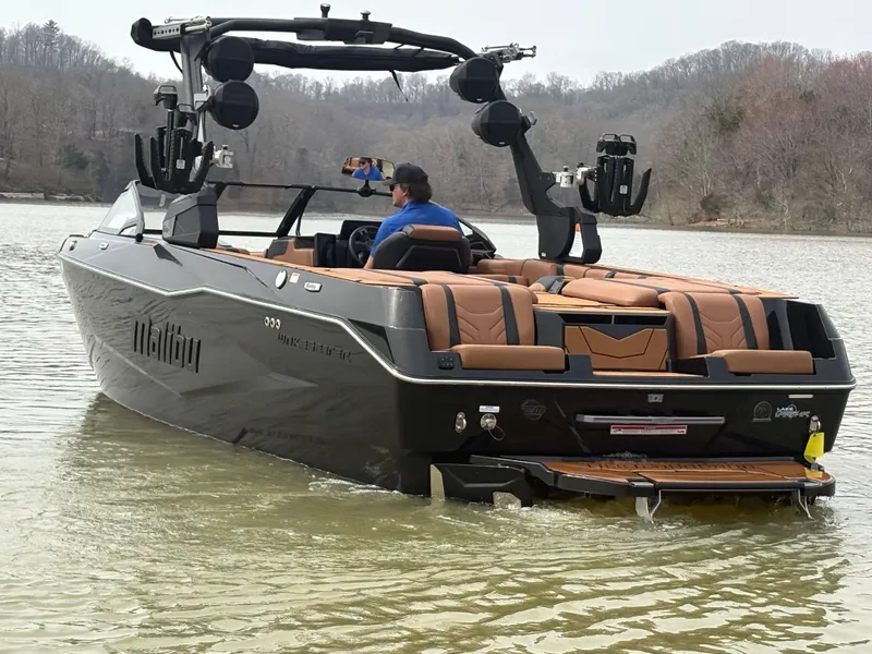 Slide: The Image of 2025 Malibu 25 LSV boat on a lake, featuring sleek design and luxurious seating. - 10