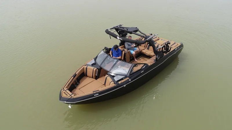 Slide: The Image of 2025 Malibu 25 LSV boat on calm water, featuring sleek design and spacious seating. - 13