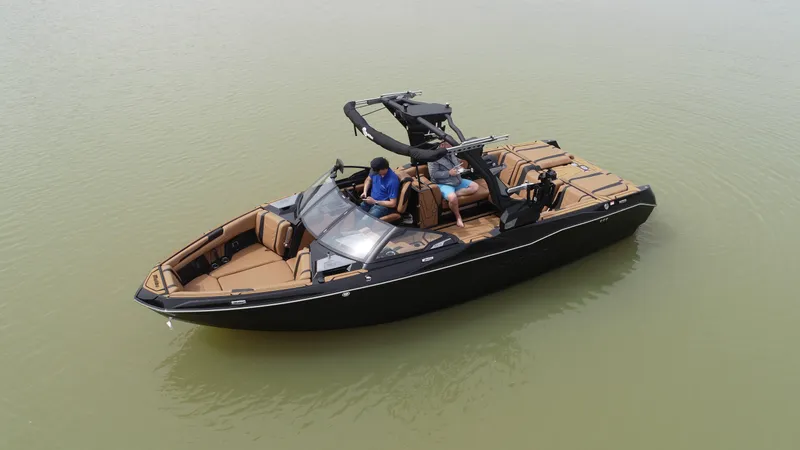 Slide: The Image of 2025 Malibu 25 LSV boat on calm water, featuring sleek design and tan seating. - 14
