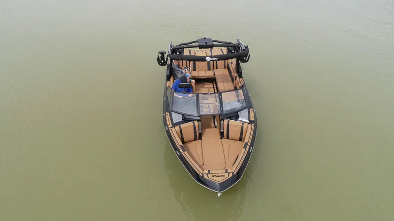Slide: The Image of 2025 Malibu 25 LSV boat on calm water, featuring luxurious seating and sleek design. - 15