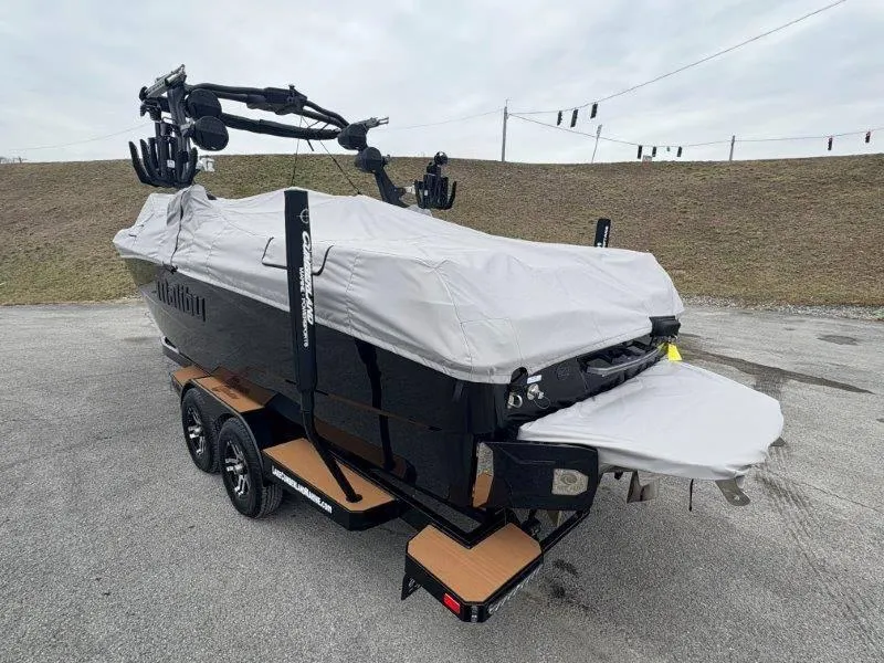 Slide: The Image of 2025 Malibu 25 LSV boat covered, on trailer, parked outdoors. - 30