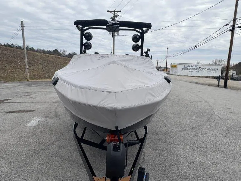 Slide: The Image of 2025 Malibu 25 LSV boat covered and parked on a paved lot. - 31