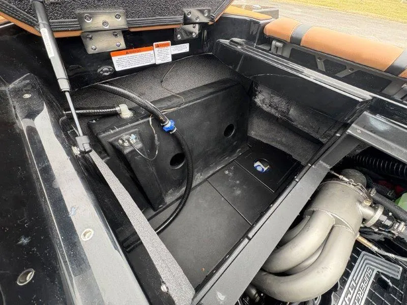 Slide: The Image of 2025 Malibu 25 LSV engine compartment with visible components and warning labels. - 43