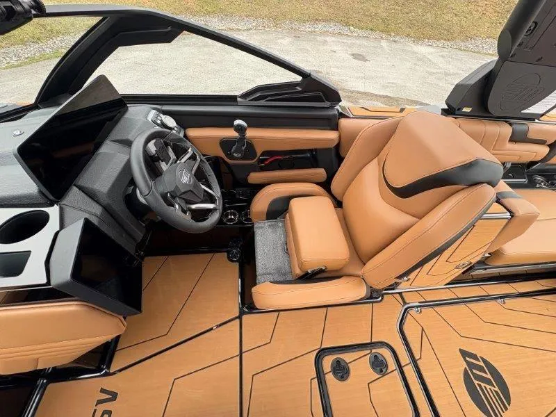 Slide: The Image of 2025 Malibu 25 LSV boat interior with tan leather seats and modern dashboard. - 47