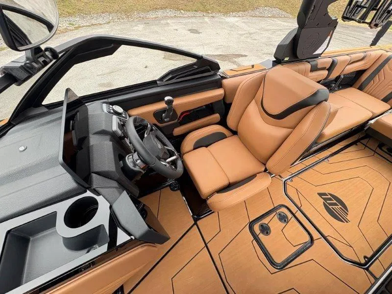 Slide: The Image of 2025 Malibu 25 LSV boat interior with tan leather seats and modern dashboard design. - 49