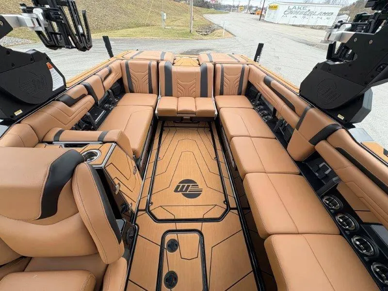 Slide: The Image of 2025 Malibu 25 LSV boat interior with luxurious tan seating and sleek design. - 50