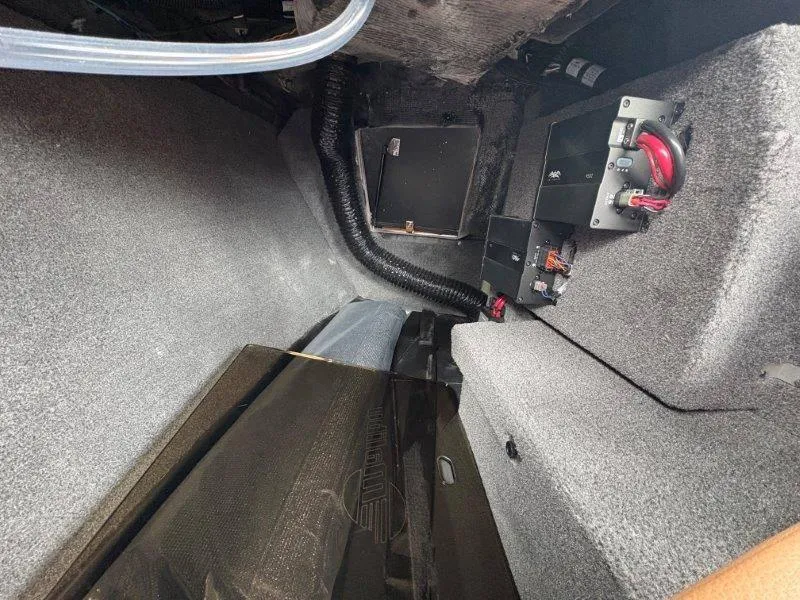 Slide: The Image of Interior view of a 2025 Malibu 25 LSV boat compartment with wiring and components. - 54