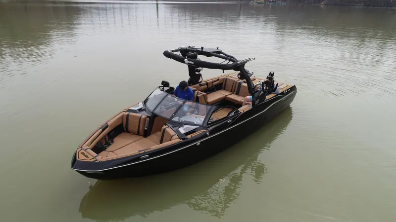 Slide: The Image of 2025 Malibu 25 LSV boat on calm water, featuring sleek design and spacious seating. - 6