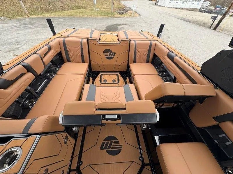 Slide: The Image of Luxurious interior of 2025 Malibu 25 LSV boat with tan and black seating. - 65