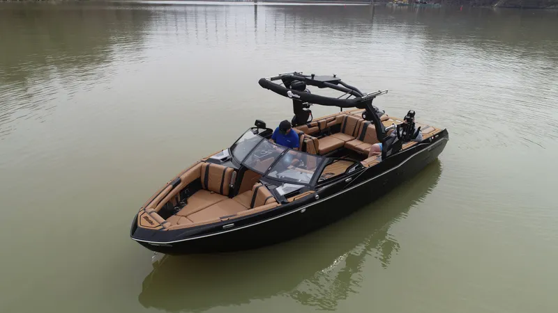 Slide: The Image of 2025 Malibu 25 LSV boat on calm water, featuring sleek design and spacious seating. - 7