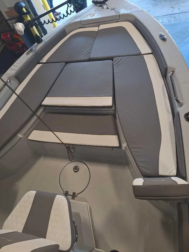 Slide: The Image of 2025 Ranger 2660 Bay boat interior with gray and white cushioned seating. - 2
