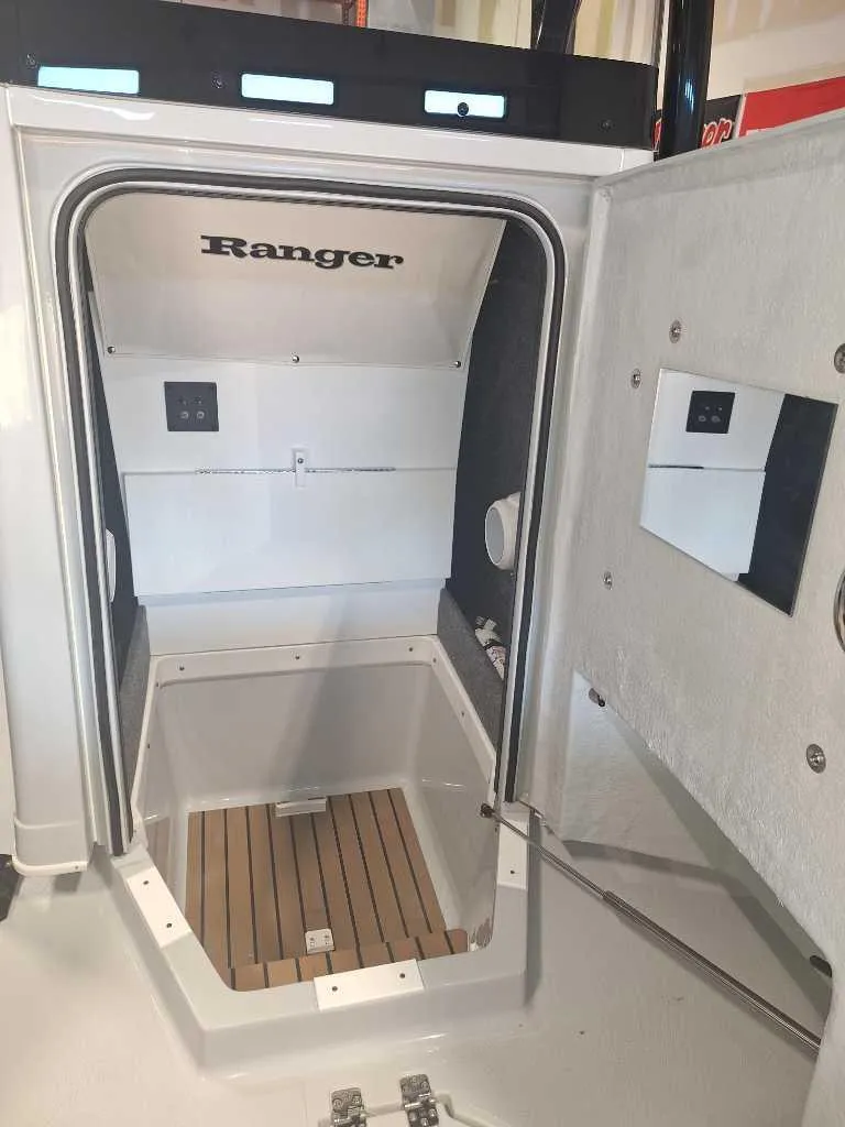 Slide: The Image of 2025 Ranger 2660 Bay boat interior with open cabin door and wood flooring. - 5