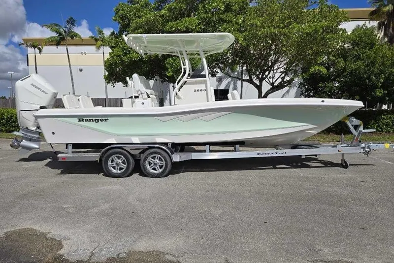 Slide: The Image of 2025 Ranger 2660 Bay boat on trailer, parked outdoors, side view. - 1