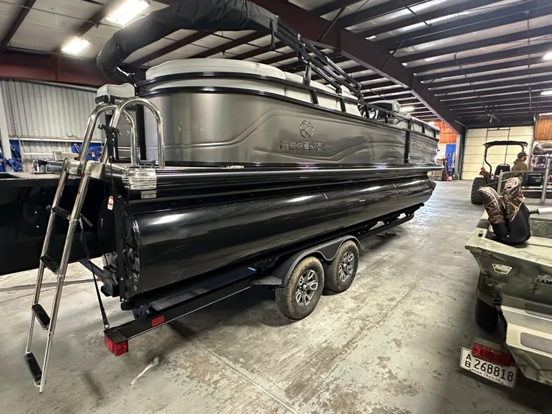 Slide: The Image of 2025 Regency 230 DL3 pontoon boat on trailer in a warehouse setting. - 2