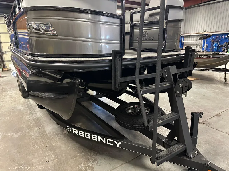 Slide: The Image of 2025 Regency 230 DL3 pontoon boat on trailer in a warehouse setting. - 7