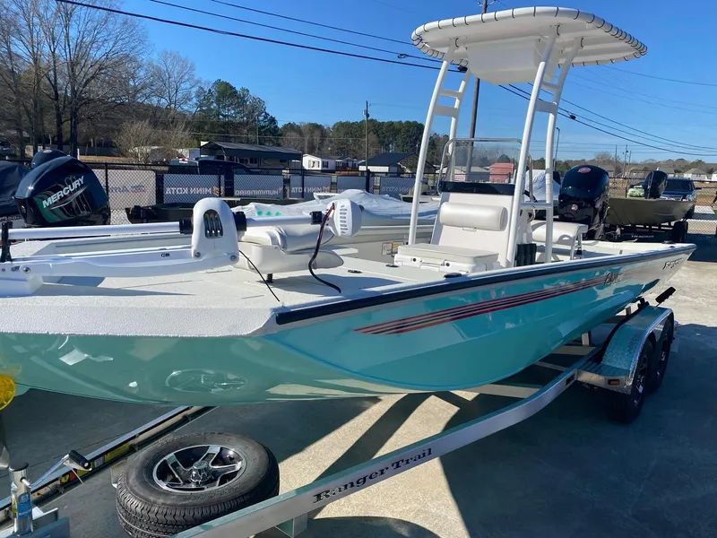 Slide: The Image of 2025 Ranger RB200 boat on trailer, turquoise hull, T-top, parked outdoors. - 2