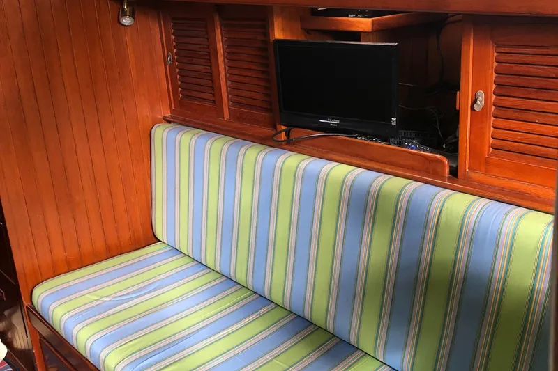 Slide: The Image of Interior of 1985 Tayana 37 sailboat with striped seating and wooden paneling. - 17