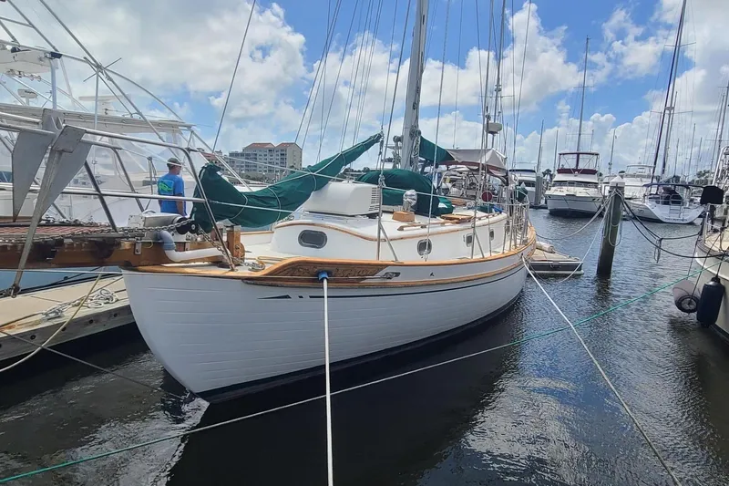 Slide: The Image of 1985 Tayana 37 sailboat docked at marina under blue sky. - 2