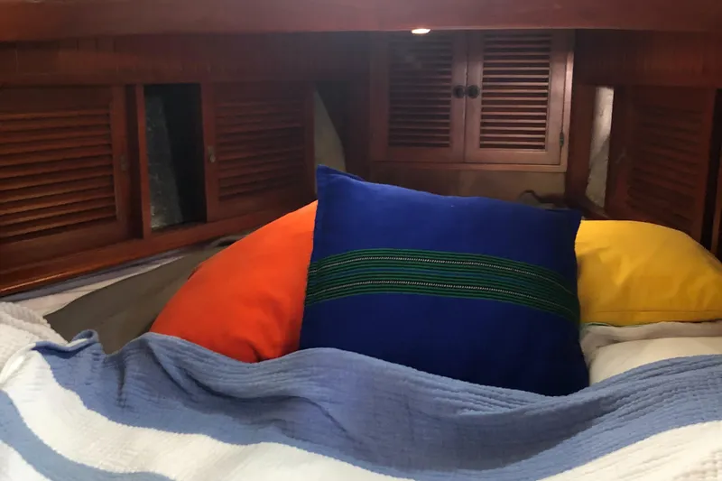 Slide: The Image of Cozy cabin interior of 1985 Tayana 37 sailboat with colorful pillows and wooden accents. - 21