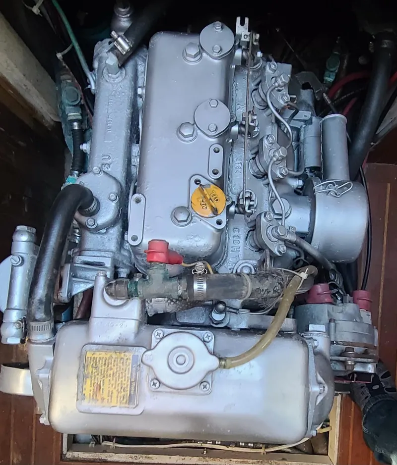 Slide: The Image of Engine of a 1985 Tayana 37 sailboat, showcasing mechanical components and hoses. - 26
