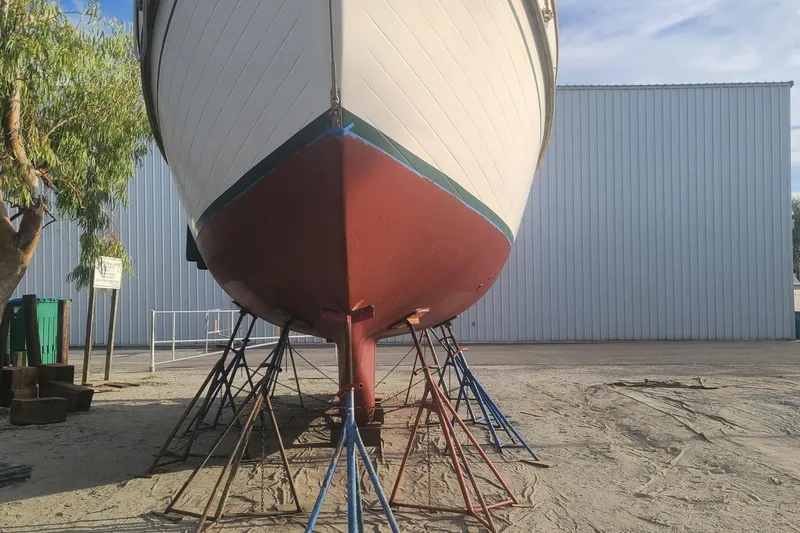 Slide: The Image of 1985 Tayana 37 sailboat on stands, ready for maintenance at a boatyard. - 28