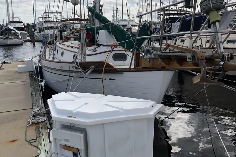 Slide: The Image of 1985 Tayana 37 sailboat docked at marina, surrounded by other boats. - 3