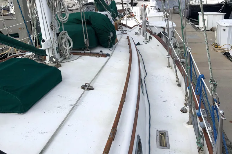 Slide: The Image of 1985 Tayana 37 sailboat deck with green covers and rigging at dock. - 4